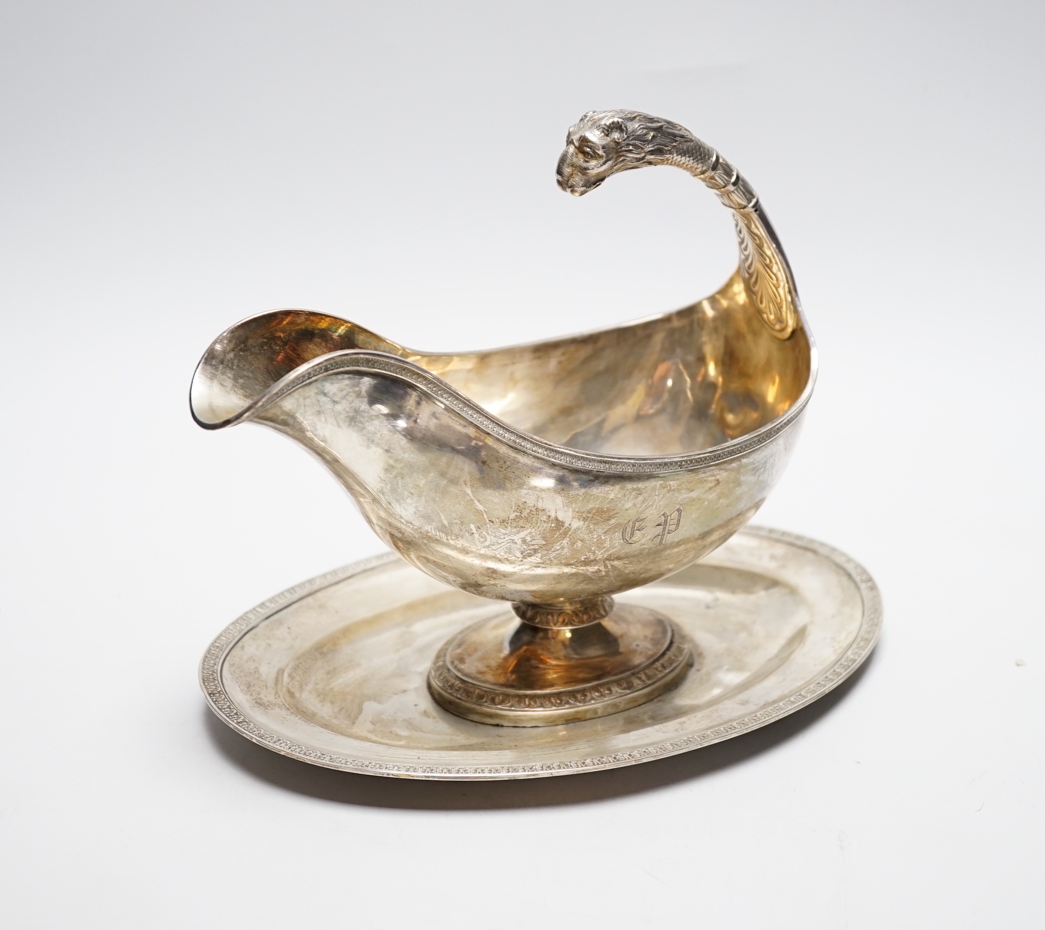 A continental white metal sauceboat on stand, with flying scroll leopard's head handle, length 23.8cm, 24.7oz.